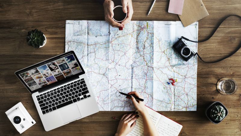 Planifier un voyage avec un ordinateur et une carte