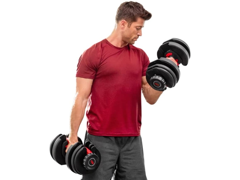 Un homme fait des flexions de biceps en utilisant les haltères ajustables SelectTech 552 de Bowflex.