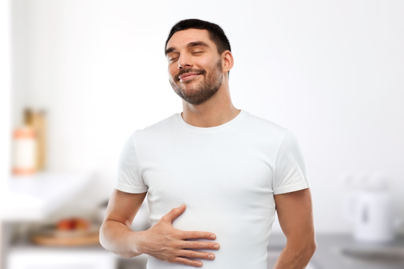 Homme en T-shirt blanc se touchant joyeusement le ventre